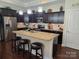 Well-lit kitchen features dark cabinetry, granite countertops, stainless steel appliances, and a functional island at 1112 Avalon Pl, Stallings, NC 28104