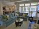 Open living room with a large sectional sofa, bright windows, and a view into the kitchen and dining area, perfect for entertaining at 1112 Avalon Pl, Stallings, NC 28104
