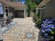 Charming patio with stone pavers, blooming hydrangeas, and an outdoor dining area, perfect for entertaining guests at 1112 Avalon Pl, Stallings, NC 28104