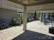 Relaxing covered patio with stone pavers, blooming hydrangeas, and a comfortable outdoor seating area for enjoying leisure time at 1112 Avalon Pl, Stallings, NC 28104