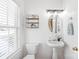 Stylish powder room features a pedestal sink, modern shelving, and natural light at 11122 Aprilia Ln, Cornelius, NC 28031