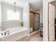 Bright primary bathroom with a soaking tub, tile floors, and separate tiled shower at 12510 Pine Terrace Ct, Charlotte, NC 28273