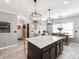 Well-lit kitchen featuring an island with seating, a dining area, and ample storage space at 12510 Pine Terrace Ct, Charlotte, NC 28273