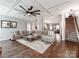 Bright living room featuring a large sectional sofa, tray ceiling, and staircase at 12510 Pine Terrace Ct, Charlotte, NC 28273