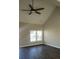 Open living area with a vaulted ceiling, a ceiling fan, a large window, and dark wood-look flooring at 1303 W Gold Street Ext, Kings Mountain, NC 28086