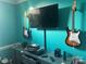 Bedroom featuring turquoise walls, media center, TV, and guitars hanging on the wall at 1308 Moonshadow Ln, Shelby, NC 28150