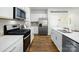 Close up of an open-concept kitchen featuring stainless steel appliances, quartz countertops and wooden floors at 1447 Mammoth Rd, Hickory, NC 28602