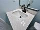 Modern bathroom sink featuring quartz countertop and black faucet with a matching framed mirror at 1946 Academy St, Charlotte, NC 28205