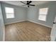 Spacious bedroom features light-colored walls, wood-look flooring, two windows, and a ceiling fan at 1946 Academy St, Charlotte, NC 28205