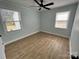 Well-lit bedroom featuring wood-look flooring, light blue walls, and a ceiling fan at 1946 Academy St, Charlotte, NC 28205