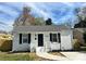 Charming, newly renovated single story home featuring freshly painted white brick exterior, black shutters, and a walkway to the front door at 1946 Academy St, Charlotte, NC 28205