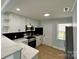 Well-lit kitchen with stainless steel appliances, white cabinets, modern countertops, and stylish backsplash offers culinary charm at 1946 Academy St, Charlotte, NC 28205