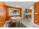 A dining area with wood-paneled walls, tile floor, and a view into the kitchen at 230 Dunham Ave, Salisbury, NC 28146