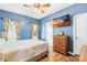 Comfortable blue bedroom with ceiling fan, wooden dresser, and scenic TV display at 2966 Huckleberry Hill Dr, Fort Mill, SC 29715