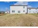 Backyard view of a two-story home with a concrete patio and lush green lawn at 3077 Light Ridge Sw Ct, Concord, NC 28027