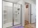 Bright bathroom featuring a glass-enclosed shower with built-in shelves and neutral color palette at 3077 Light Ridge Sw Ct, Concord, NC 28027