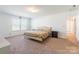 A sunlit bedroom boasts neutral walls, plush carpet, and two windows for plenty of light at 3077 Light Ridge Sw Ct, Concord, NC 28027