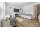 Bright living room with a fireplace, neutral sofas, and hardwood floors with sunny natural light at 3077 Light Ridge Sw Ct, Concord, NC 28027