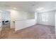 Spacious loft area with natural light, neutral carpet, and white walls at 3077 Light Ridge Sw Ct, Concord, NC 28027