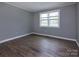 A bedroom with laminate flooring, a neutral gray paint scheme, and ample natural light at 326 Mountain View St, Gastonia, NC 28052