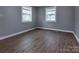 Bright bedroom with wood-look floors, gray walls, and natural light from two windows at 326 Mountain View St, Gastonia, NC 28052