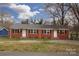 Charming brick duplex featuring black shutters, a well-maintained lawn, and convenient parking at 326 Mountain View St, Gastonia, NC 28052