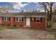 Charming red brick home featuring black shutters and well-kept landscaping at 326 Mountain View St, Gastonia, NC 28052