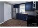 Well-lit kitchen featuring navy cabinets, stainless steel appliances, and hardwood floors at 326 Mountain View St, Gastonia, NC 28052