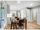 Dining area with view to the kitchen, white cabinets, stainless steel appliances, and laminate flooring at 4124 Woodfox Dr, Charlotte, NC 28277