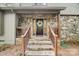 Inviting stone front porch with decorative wreath and wooden railings at 4124 Woodfox Dr, Charlotte, NC 28277