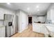 Galley kitchen with stainless steel refrigerator and white cabinets adjacent to dining area at 4124 Woodfox Dr, Charlotte, NC 28277