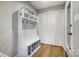 Mudroom with white storage bench, hooks, shelving and a closet for organized entry at 4124 Woodfox Dr, Charlotte, NC 28277