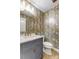 Stylish powder room with unique wallpaper, modern vanity, and gold fixtures at 4124 Woodfox Dr, Charlotte, NC 28277