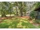 Expansive backyard features mature trees, a well-maintained lawn, and glimpses of the home's screened porch for outdoor enjoyment at 4124 Woodfox Dr, Charlotte, NC 28277