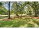 The lush backyard showcases a vast lawn and mature trees, creating a perfect space for outdoor activities and relaxation at 4124 Woodfox Dr, Charlotte, NC 28277