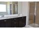 Modern bathroom featuring double sinks, dark wood cabinets, and a tiled glass door shower at 4892 Horseback Ln, Harrisburg, NC 28075