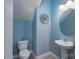 Charming powder room with blue walls, pedestal sink, and decorative mirror at 623 Hicklin Dr, Rock Hill, SC 29732