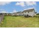 Fenced backyard featuring a spacious lawn, trampoline, garden, and black metal fencing at 7027 Waterwheel St, Concord, NC 28025