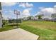 Large backyard featuring a basketball hoop, trampoline, and well-maintained lawn at 7027 Waterwheel St, Concord, NC 28025