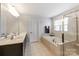 Bright bathroom with a soaking tub, glass shower, double vanity and tiled floors at 7027 Waterwheel St, Concord, NC 28025