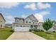 Beautiful two-story home featuring a manicured lawn, three car garage, and welcoming curb appeal at 7027 Waterwheel St, Concord, NC 28025