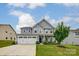 Charming two-story home with a well-maintained lawn and a three car garage in a suburban neighborhood at 7027 Waterwheel St, Concord, NC 28025