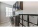 Laundry room with a front load washer and dryer, upper cabinets, and shelving at 7027 Waterwheel St, Concord, NC 28025