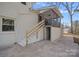 View of a home's backyard featuring a staircase leading up to a screened-in porch at 7214 Benita Dr, Charlotte, NC 28212