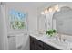 Updated bathroom with double sinks, sleek lighting, and a serene view from the window at 7214 Benita Dr, Charlotte, NC 28212