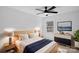 Well-lit bedroom includes a ceiling fan, dresser, and large window at 7214 Benita Dr, Charlotte, NC 28212