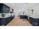 Spacious kitchen with navy blue cabinets, stainless steel appliances, and hardwood floors seamlessly connecting to dining area at 7214 Benita Dr, Charlotte, NC 28212