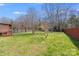 Fenced backyard with shade trees and a well-manicured lawn at 7619 Woodknoll Dr, Charlotte, NC 28217