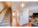 Hallway featuring hardwood floors, a staircase, and a decorative light fixture at 7619 Woodknoll Dr, Charlotte, NC 28217