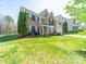 Elegant two-story home with a well-maintained lawn, brick accents, and a two-car garage at 7719 Whisperingwood Dr, Harrisburg, NC 28075